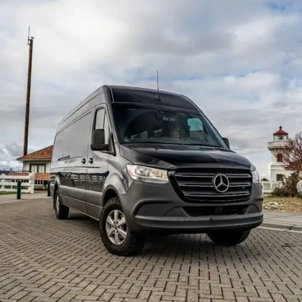 Black Mercedes-Benz Sprinter van parked near an Orlando lighthouse for a premium van rental service